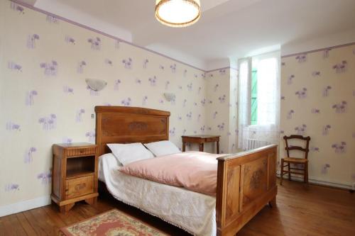 ein Schlafzimmer mit einem Bett mit einem hölzernen Kopfteil in der Unterkunft Chez brouge in Momas