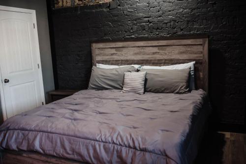 ein Bett in einem Schlafzimmer mit Ziegelwand in der Unterkunft The Heritage Lofts in Winchester