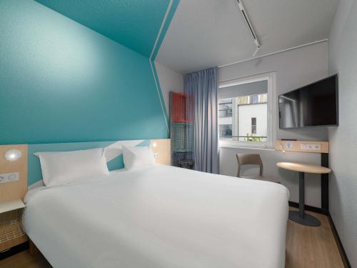 a bedroom with a white bed and a blue wall at ibis budget Hamburg St Pauli Messe - neu renoviert in Hamburg