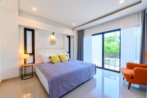 a bedroom with a bed and a large window at Sunny Blue Runway in Ban Nai Na