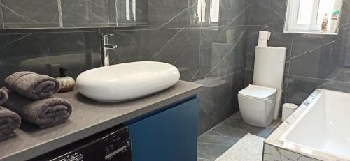 a bathroom with a sink and a toilet at Cozy penthouse with Citadel view near to Victoria in Sannat