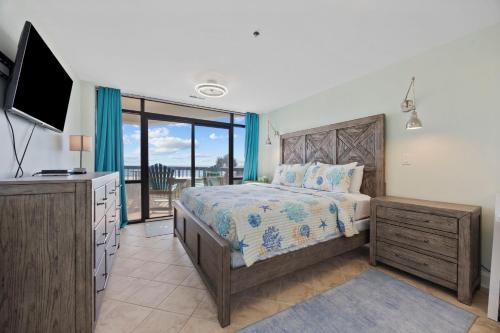 une chambre avec un lit et une télévision à écran plat dans l'établissement Beautiful & Modern Updated Oceanfront Condo for 10! Sedgefield North 103, à Myrtle Beach