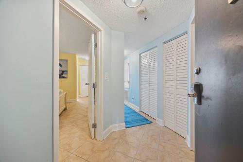 un couloir avec une porte et un tapis bleu dans l'établissement Beautiful & Modern Updated Oceanfront Condo for 10! Sedgefield North 103, à Myrtle Beach