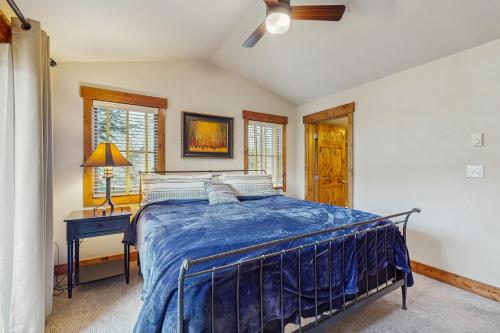 a bedroom with a bed with a blue comforter at Pines at Orehouse 301 PH2 in Steamboat Springs