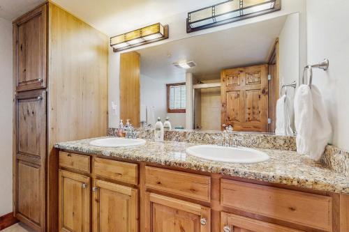 a bathroom with two sinks and a large mirror at Pines at Orehouse 301 PH2 in Steamboat Springs