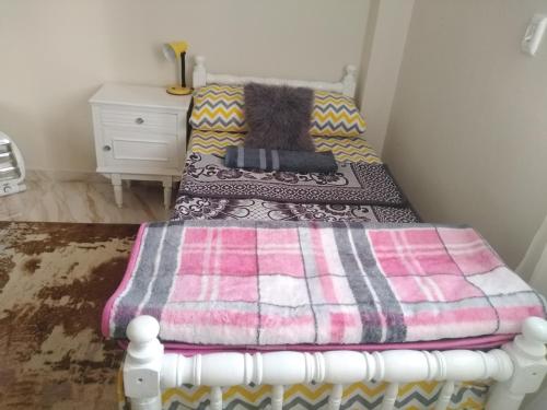 a bed with a blanket on it in a room at Gardenia Hotel in 6th Of October