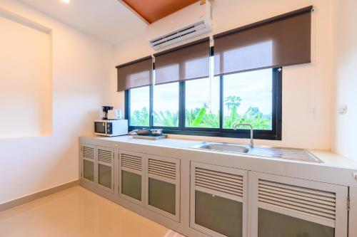 a kitchen with a sink and a window at Sunny Blue Runway in Ban Nai Na