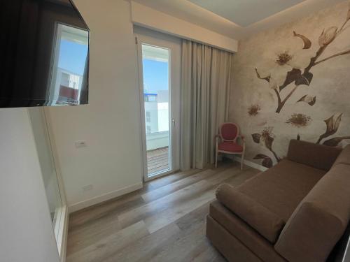a living room with a couch and a window at Park Hotel Cellini in Lido di Jesolo