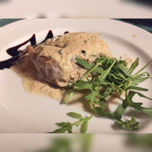 a plate of food with a piece of meat and greens at Agriturismo Sant'Agata in Piana degli Albanesi