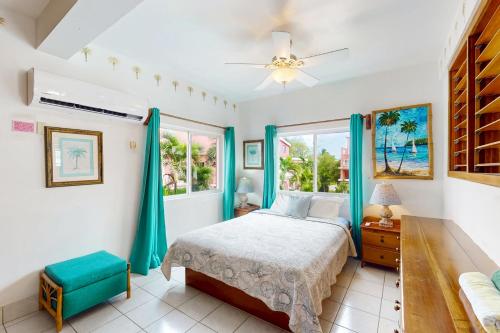 a bedroom with a bed and two windows at Palm @ Caribe Island in San Pedro