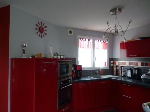 a kitchen with red cabinets and a red refrigerator at Ti harmoniel in Guingamp
