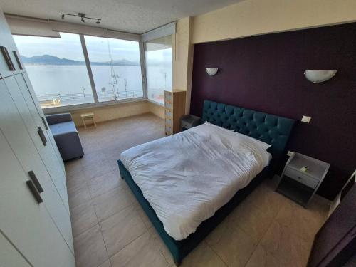 ルートラキにあるAtlas on the water - Loutrakiのベッドと大きな窓のある寝室