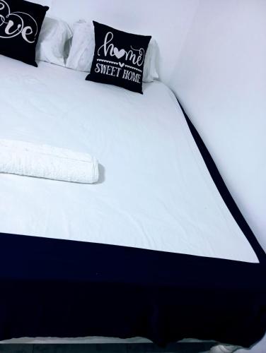 a white bed with two pillows on top of it at Talla Homes in Mombasa