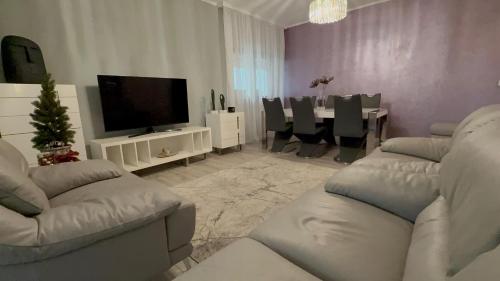 a living room with couches and a television and a table at Premium Apartment in Craiova