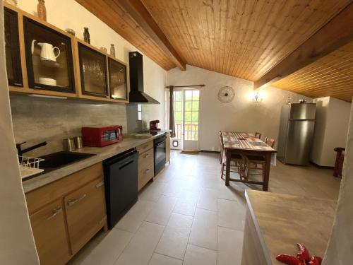 a kitchen with wooden ceilings and a table in it at Amaika karkula in Sare