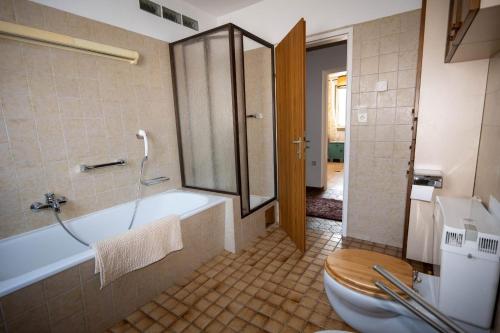 a bathroom with a bath tub and a toilet at Ferienhaus Kaiser Lothar in Reutte