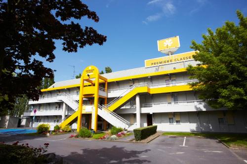 a yellow building with a basketball hoop on top of it at Premiere Classe La Rochelle Nord - Puilboreau in Puilboreau