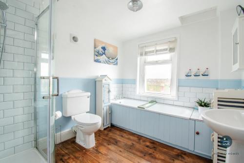 a bathroom with a toilet and a tub and a sink at Harvest Moon - cottage close to harbour in Weymouth