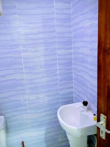 a bathroom with a white toilet and a sink at Talla Homes in Mombasa