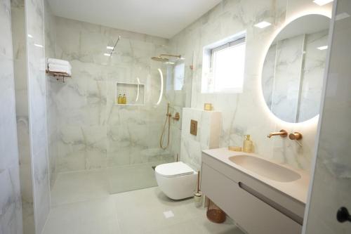 biała łazienka z toaletą i umywalką w obiekcie ווילה בנאות לון w mieście Beer Szewa