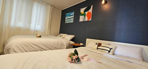a room with two beds with flowers on them at BinsHeim HBC - Seoul's Aesthetic Stay with the best Night view Rooftop in Seoul