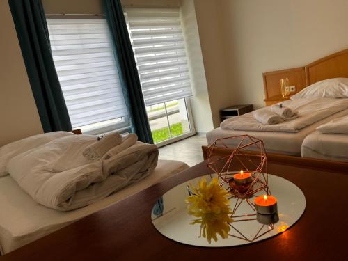 a bedroom with two beds and a table with two candles at Rohrbacher Herz in Rohrbach in Oberösterreich