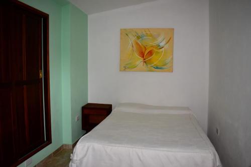 サンタ・ロサ・デ・カラムチタにあるSierras Del Molleの壁に絵が掛かっている部屋のベッド