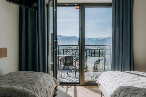 a bedroom with a balcony with a view of the mountains at Willa Janowa & SPA in Bukowina Tatrzańska