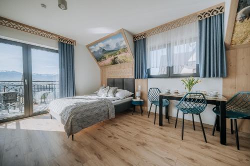 a bedroom with a bed and a table and chairs at Willa Janowa in Bukowina Tatrzańska