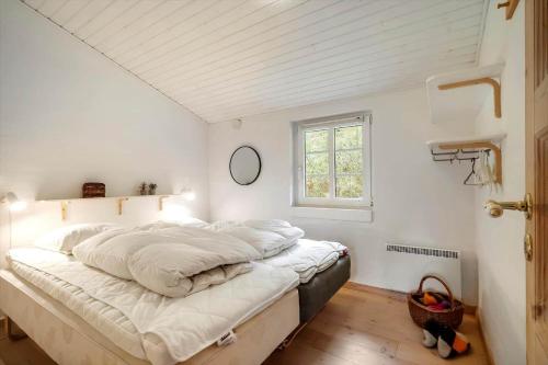 een slaapkamer met een groot wit bed met een raam bij 10292-Ulfborg-Baekbyvej-15 in Øby