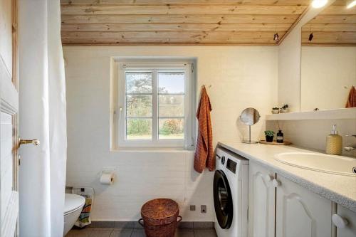 een badkamer met een wasmachine en een wastafel bij 10292-Ulfborg-Baekbyvej-15 in Øby