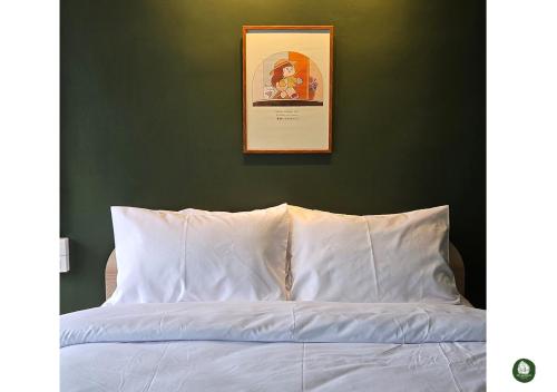 a bedroom with a white bed with a green wall at Obahomu Vacation House for 4-8 pax, 5 min walk to Icon Siam in Bangkok