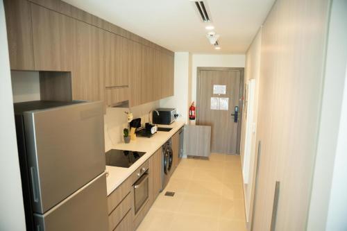 a kitchen with a stainless steel refrigerator and cabinets at Premium Studio in Yas Golf Collection in Abu Dhabi
