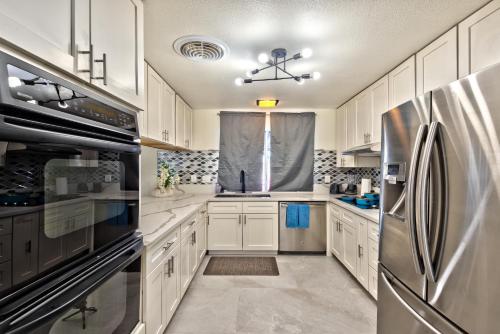 a kitchen with white cabinets and a stainless steel refrigerator at Vila Hearts in Las Vegas