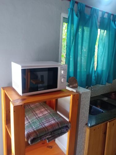 a microwave sitting on top of a table at La casita de Pablo in Santa Teresita