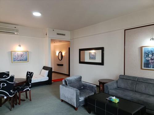 een woonkamer met een bank, een tafel en stoelen bij Eco suites at times square in Kuala Lumpur