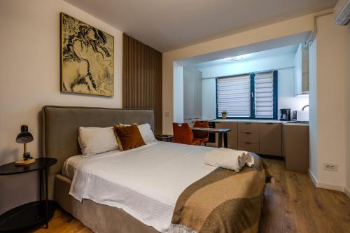 a bedroom with a large bed and a kitchen at Luxe Studio by Blvd 47B5 - Quiet & Exclusive Stay in Bucharest