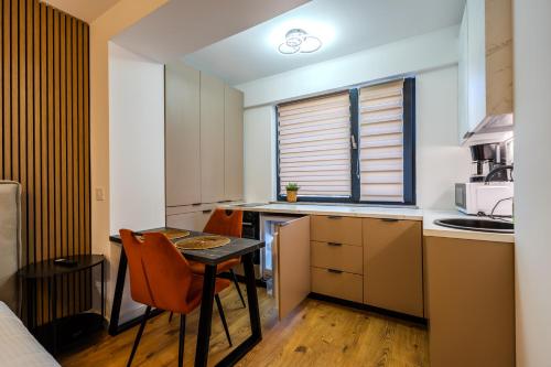 a small kitchen with a table and chairs in a room at Luxe Studio by Blvd 47B5 - Quiet & Exclusive Stay in Bucharest