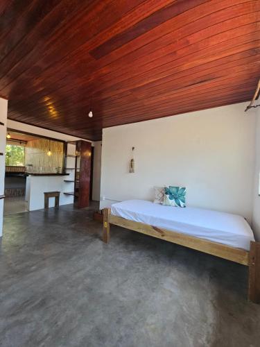 een slaapkamer met een groot bed met een houten plafond bij Pousada Zen Caraiva in Caraíva