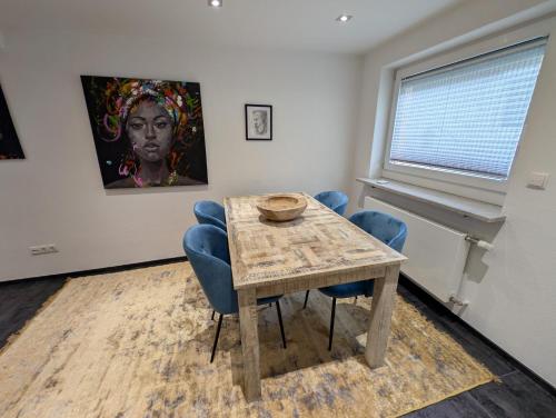 een tafel en stoelen in een kamer met een schilderij bij Modern habitable gallery, centrally located in Hirschaid in Hirschaid