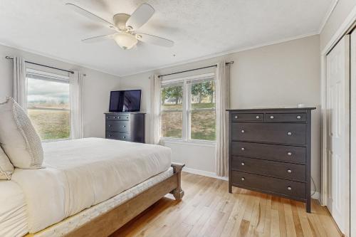 BurdettにあるSeneca Lake Overlook - Unit Aのベッドルーム1室(ベッド1台、天井ファン、ドレッサー付)