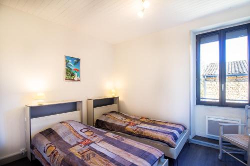 due letti in una stanza con finestra di Gite De L'école a La Mouline