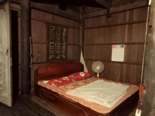 Un dormitorio con una cama en una habitación de madera. en Sconvolt Homestay, en Kratié
