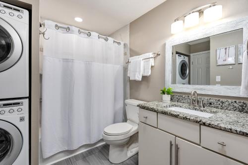 a bathroom with a toilet sink and a washer and dryer at Commodore's Retreat 305 in Seagrove Beach