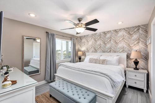 a bedroom with a white bed and a mirror at Commodore's Retreat 305 in Seagrove Beach
