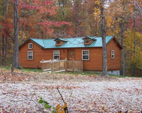 a large wooden house with a porch in the woods at Mammoth Cave Accommodation for a Kentucky Glamping Experience in Mammoth Cave