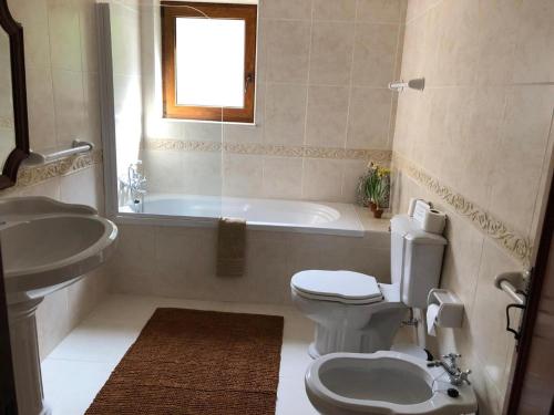 ein Badezimmer mit Toilette, Badewanne und Waschbecken in der Unterkunft Casa Das Flores in Bouro