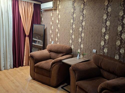 ein Wohnzimmer mit zwei Stühlen und einem Tisch in der Unterkunft Comfort apartment in Krywyj Rih