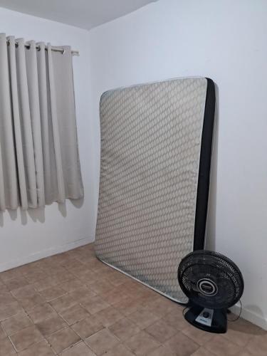 un ventilateur placé dans une pièce à côté d'un radiateur dans l'établissement Apto 2 quartos Grã Duquesa, à Governador Valadares