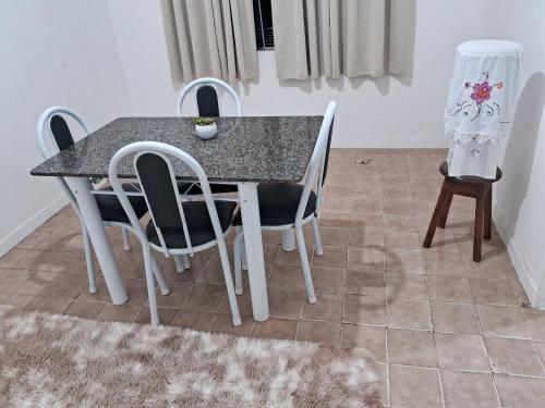 une table de salle à manger et des chaises dans une pièce dans l'établissement Apto 2 quartos Grã Duquesa, à Governador Valadares